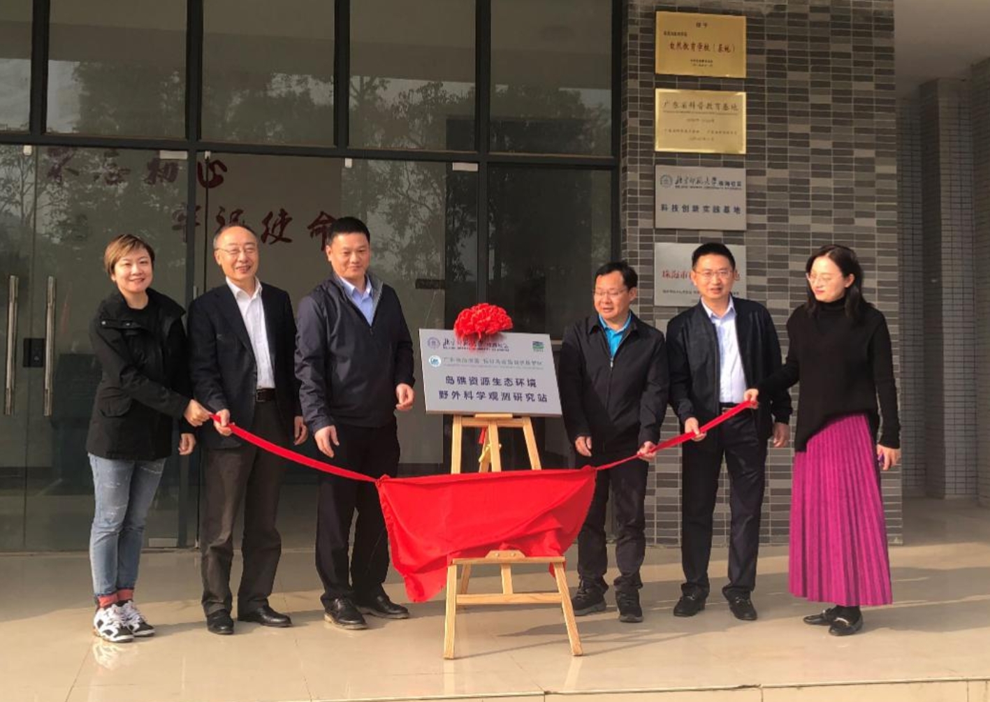 A group of people standing in front of a building&#xA;&#xA;Description automatically generated with low confidence